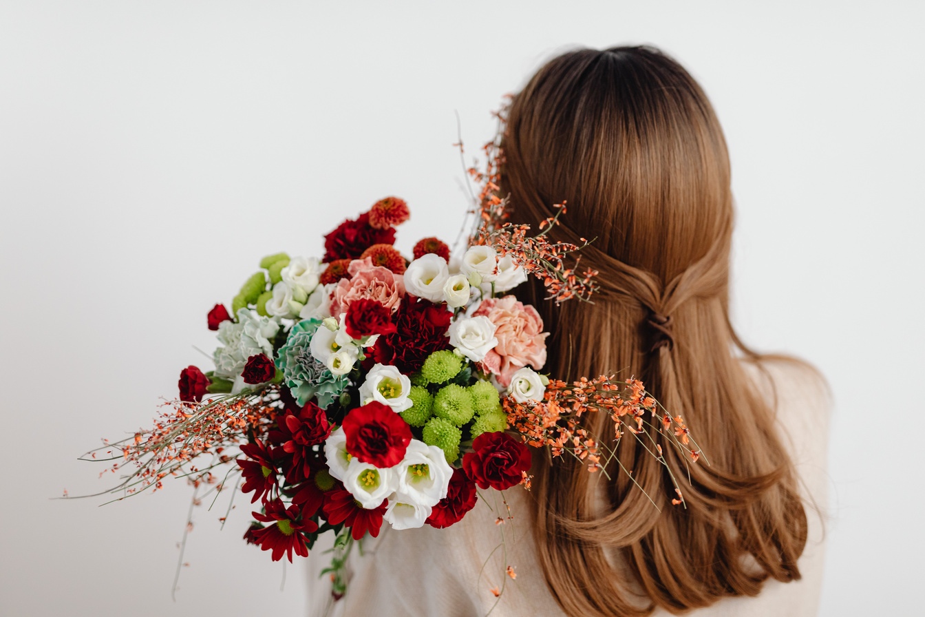 Back View of a Woman Holding a Beautiful Bouquet
